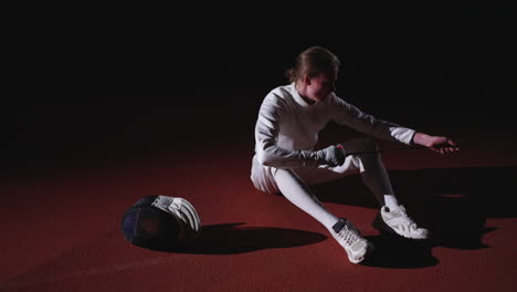 fencer sitting on the floor