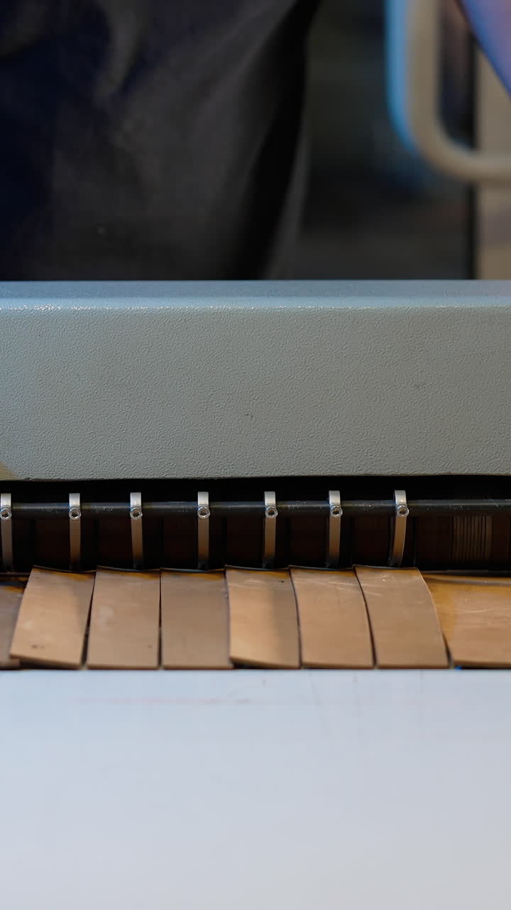 Master cutting leather on a special machine in workshop. Professional craftsman working in sewing industry. Procedure for the manufacture things from leather. Vertical video
