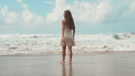 happy girl enjoying summer sunrise at seaside. young woman staying at seashore.