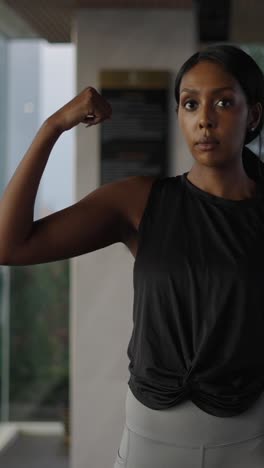 woman exercising with dumbbells and flexing arm muscles