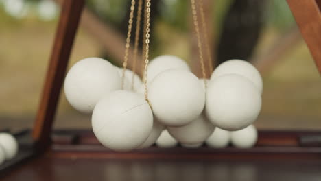 bolas blancas suspendidas en cadenas por encima del campo de juego de madera