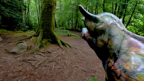 artistic cow statue amidst lush forest scenery