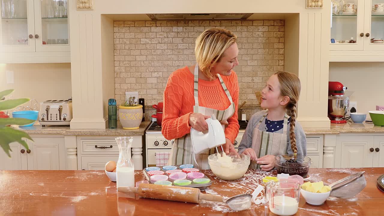 Smiling mother and daughter mixing mixture with electronic whisk 4K 4k