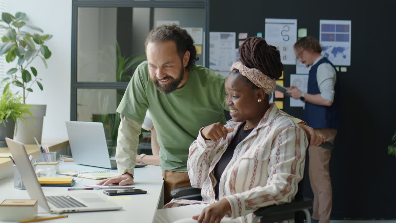 Man Talking with Female Colleague in Wheelchair