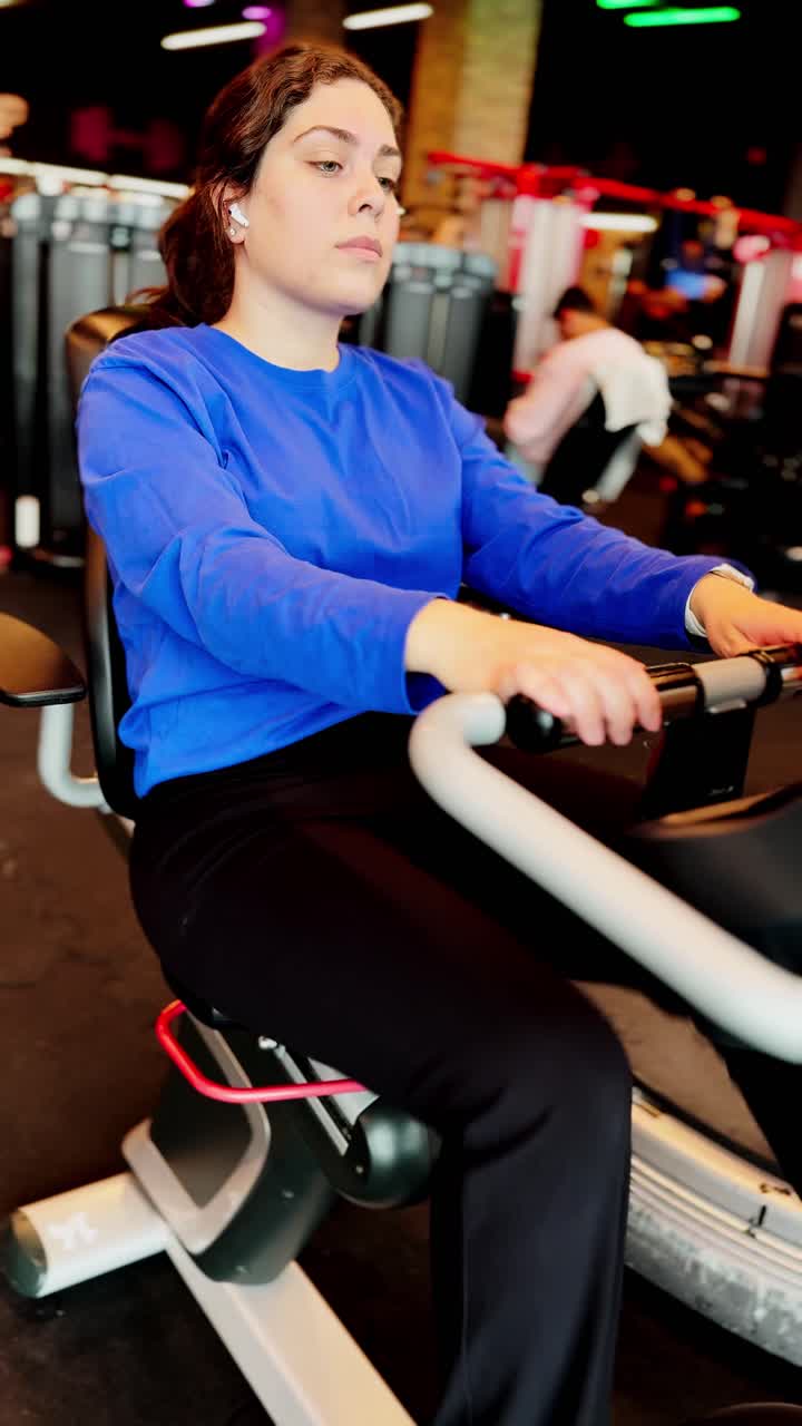Young woman doing cardio training on stationary bike