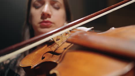 talented female violinist is playing violin on scene of music hall closeup view of fiddle in hands