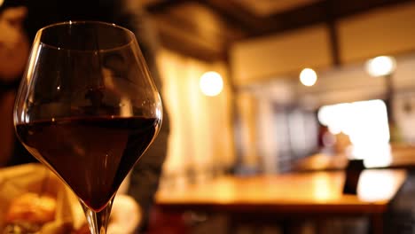 primer plano de una copa de vino rojo en un entorno cálido