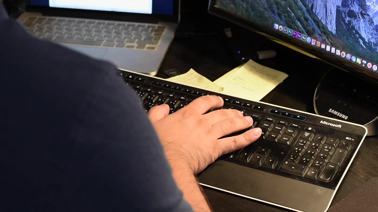 Digitando no teclado, tomada por cima do ombro.
