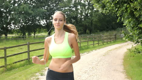 woman running in countryside wearing earphones