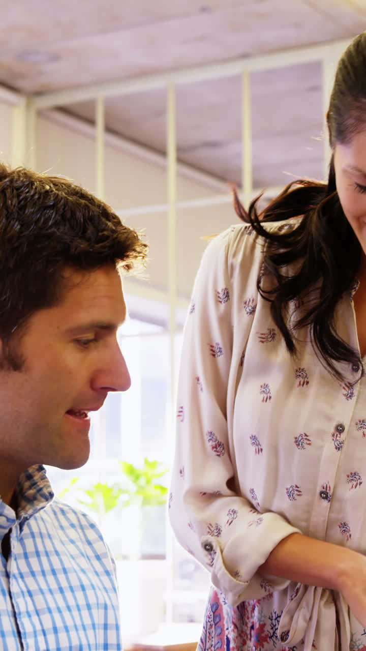 ejecutivo de negocios masculino y femenino interactuando a través de una tableta digital