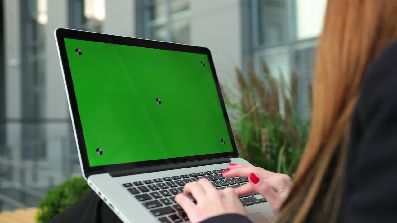 las manos de las mujeres trabajando en la pantalla verde de la computadora portátil. la mujer usando la llave de croma del portátil