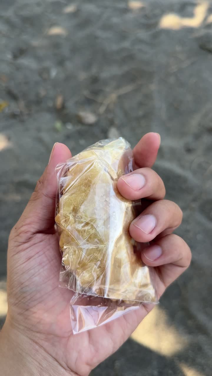 Mano che tiene un pasticcino fritto confezionato con peperoncino verde.
