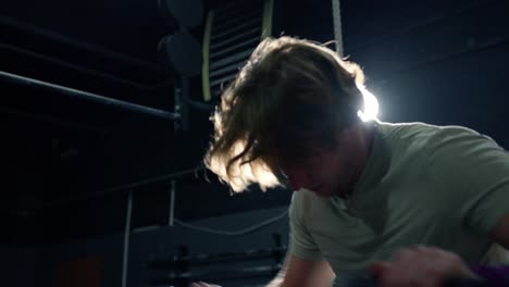 close up of tired man working hard pedaling on the stationary bike in the crossfit box