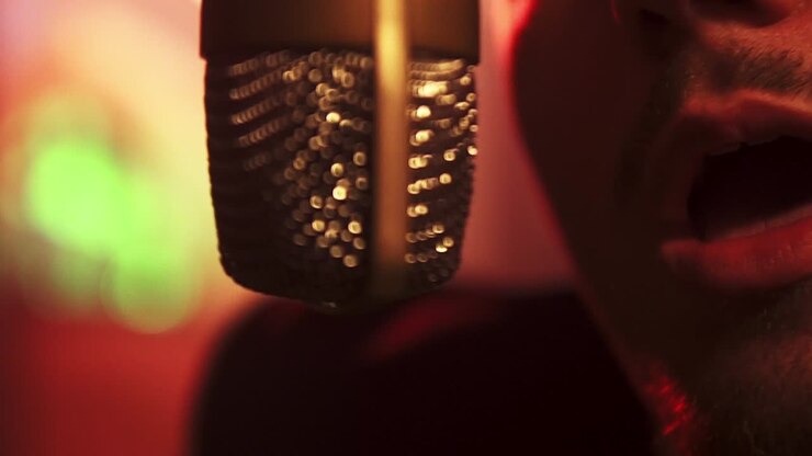bokeh in slowmotion di un uomo che canta in un microfono sospeso in studio