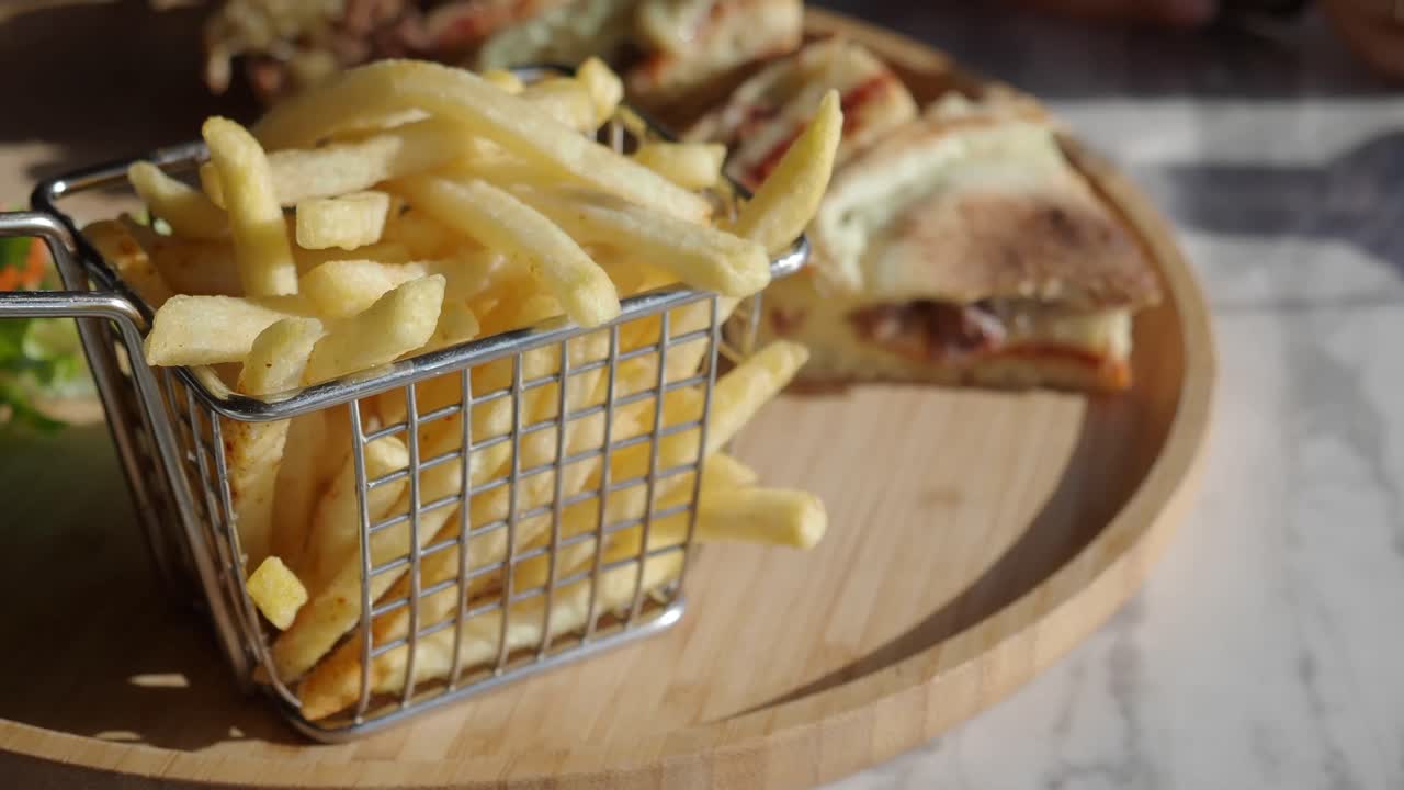 Batatas fritas servidas com sanduíche e salada
