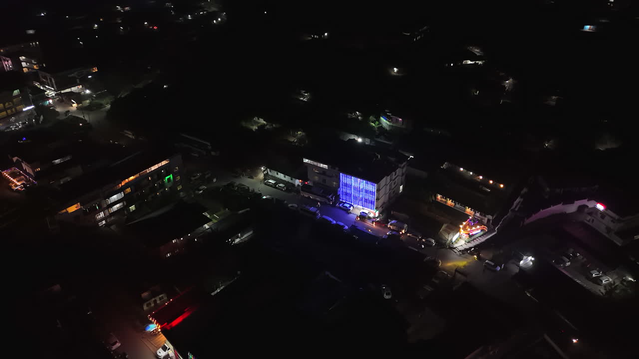 Aerial overview of traffic on the illuminated streets of Munnar, night in India