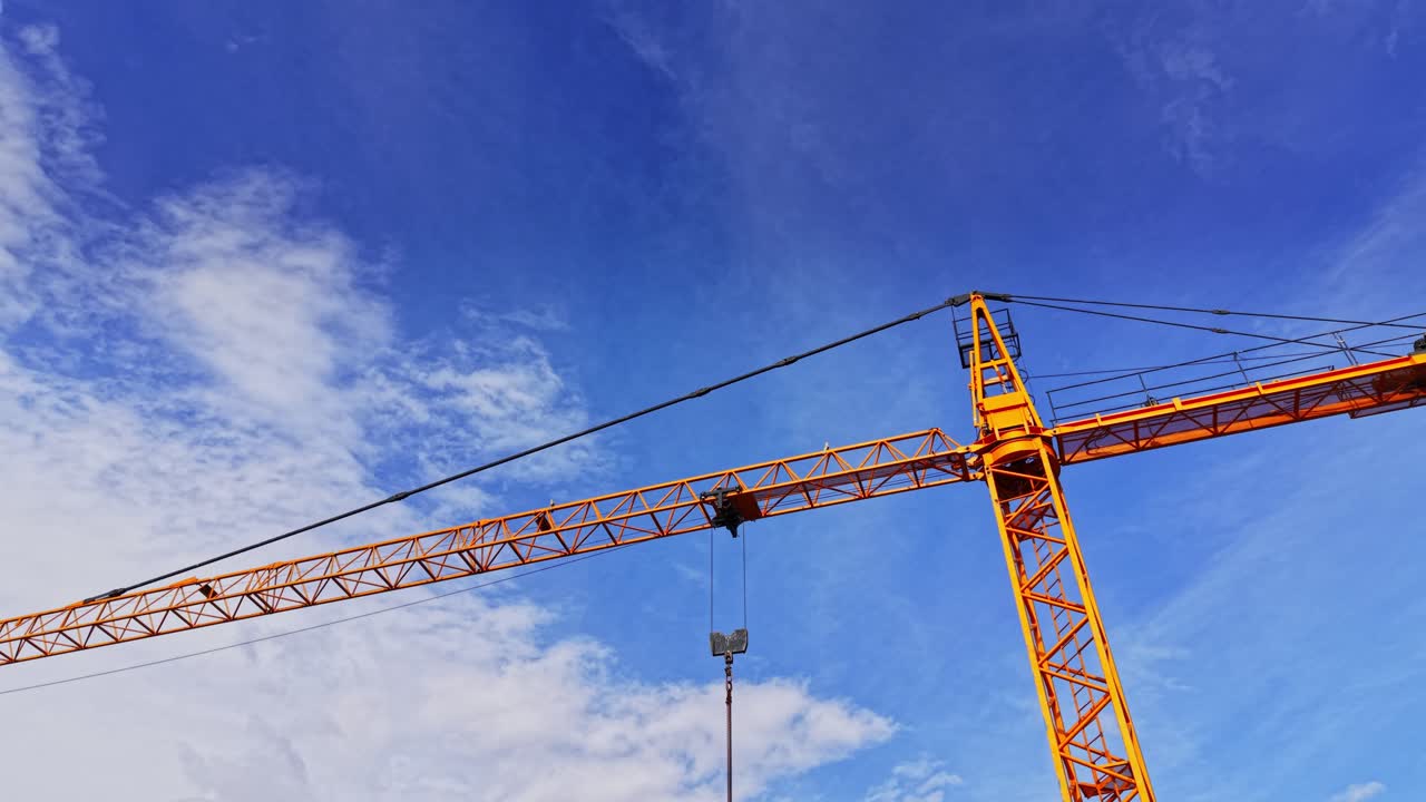 Construction crane towers over urban landscape under clear blue sky