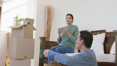 video of happy diverse couple unpacking boxes after moving in