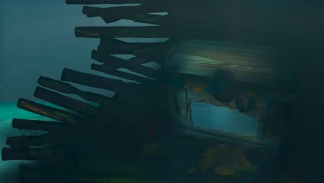 animation of a treasure chest on a underwater wooden shipwreck with lots of coins and jewels, with waves, sunrays and bubbles