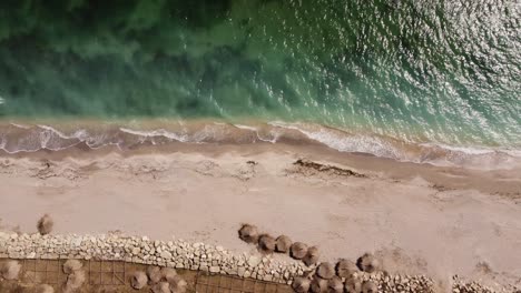 Aerial-View-of-Waves-and-Water-Crashing-On-To-Sandy-Beach