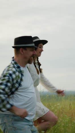 las parejas se toman de la mano y corren a través de un campo cubierto de hierba al atardecer, irradiando alegría y conexión. el hombre lleva un sombrero negro y una camisa a cuadros, mientras que la mujer está vestida con un vestido blanco y un sombreiro a juego
