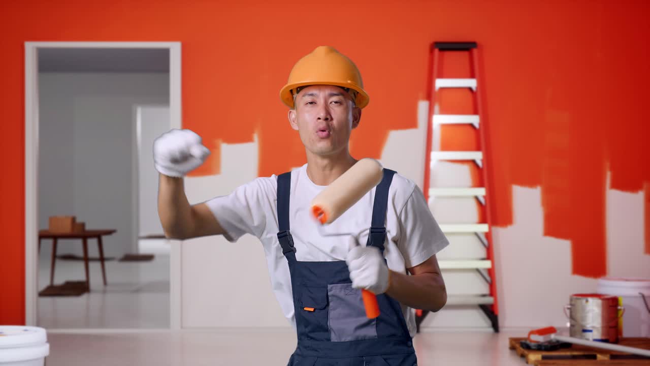 A painter having fun during painting a room