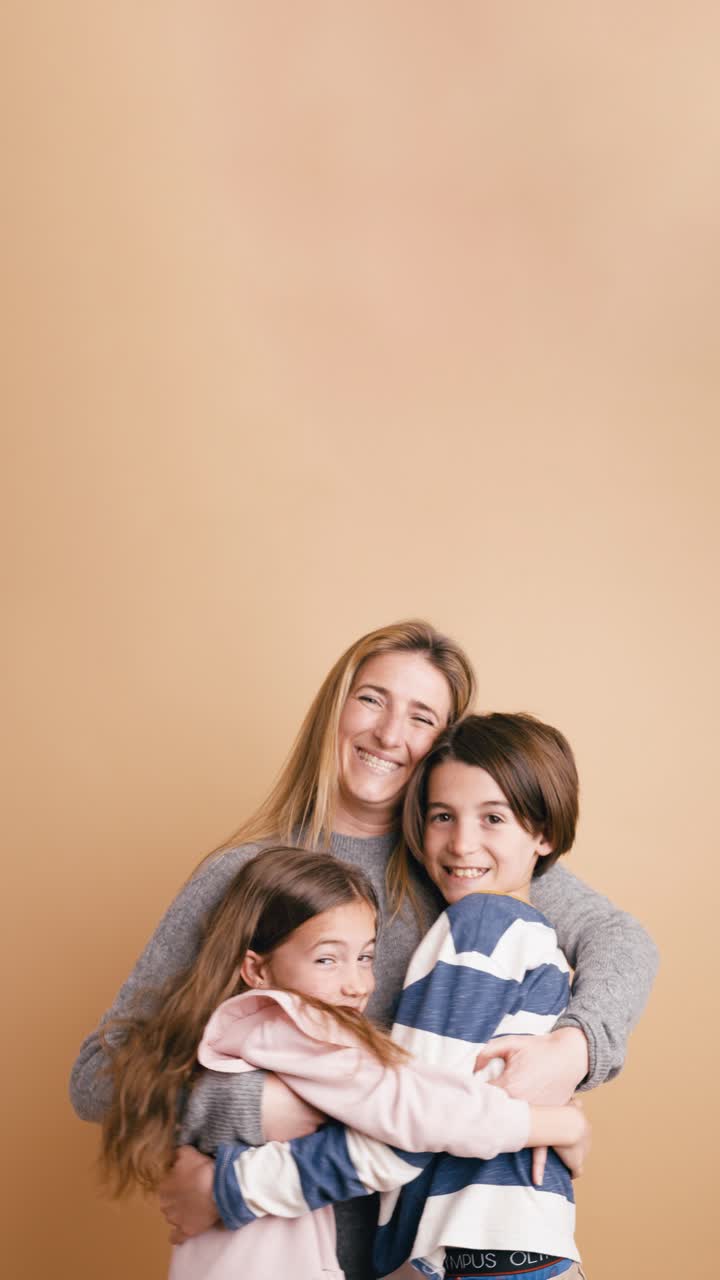 Madre amorevole che abbraccia i suoi due figli felici