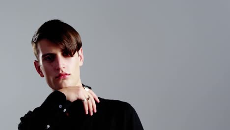 androgynous man posing against grey background