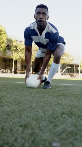 vertical video: rugby player preparing to pass ball on field, focused and determined