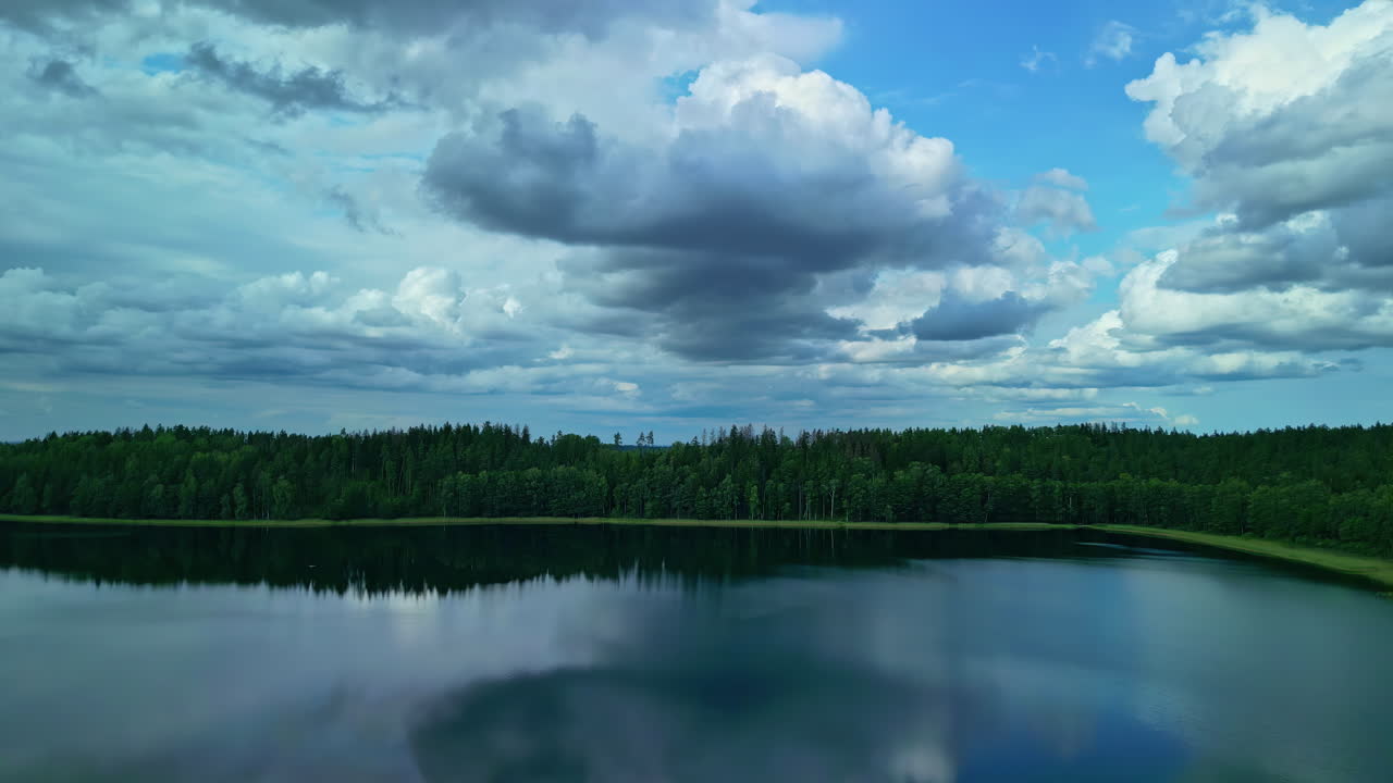 reflejos de nubes sobre un lago con una línea de árboles forestales en el pintoresco campo de letonia