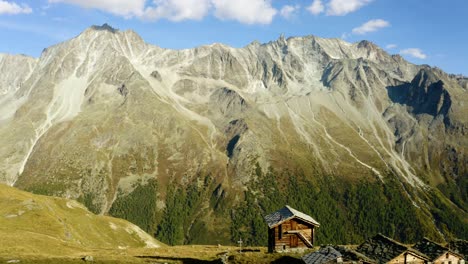 aerial orbit around small "alpage" chalets revealing high mountain peaks in the background autumn colors in arolla, valais - switzerland