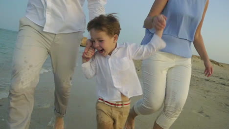 young family running on the beach