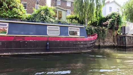 narrowboat moving along camden canal in london