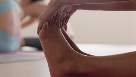 Cerrar-Los-Pies-De-Una-Mujer-Afroamericana-En-Clase-De-Yoga-Estirándose-Practicando-Una-Pose-De-Curvatura-Hacia-Adelante-Sentada-Disfrutando-De-Un-Estilo-De-Vida-Saludable-Ejercicio-De-Grupo-De-Meditación