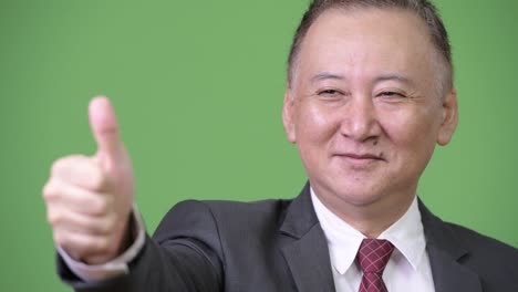 mature japanese businessman giving thumbs up