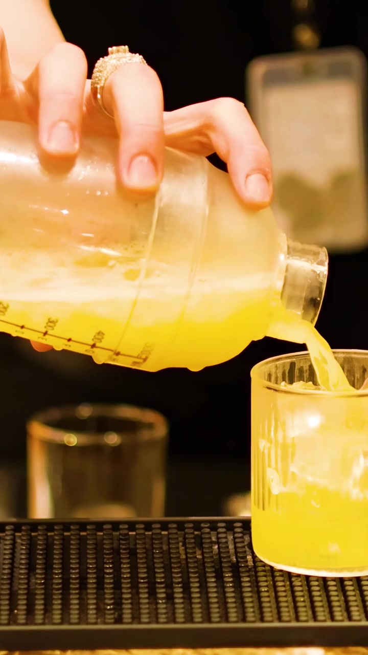 Bartender pouring cocktail into a glass