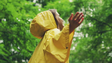 view from below of a happy girl in a yellow raincoat