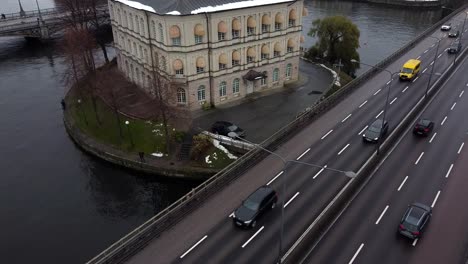 órbita aérea alrededor de la residencia histórica fuera de la bulliciosa carretera en un frío día de invierno escandinavo