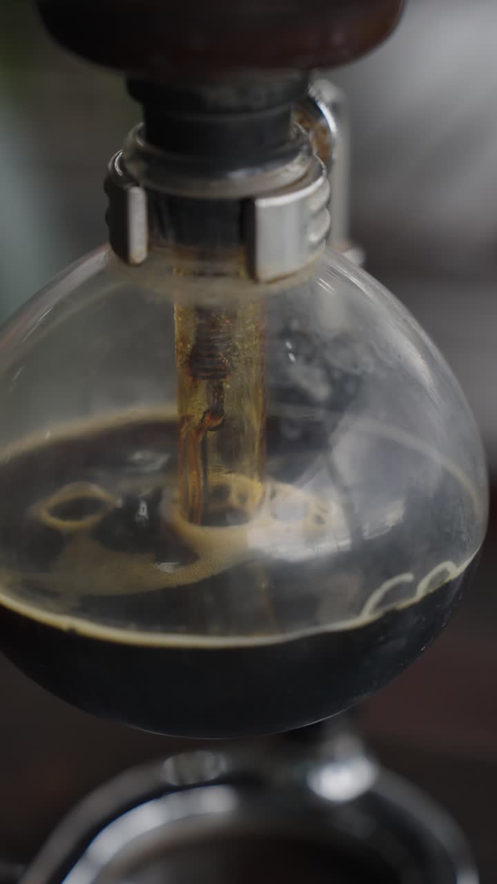Coffee running into glass container after brewing, close up view