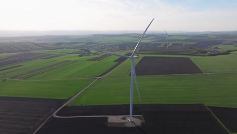 Wind-turbine-in-a-green-and-brown-agricultural-field-on-a-clear-day