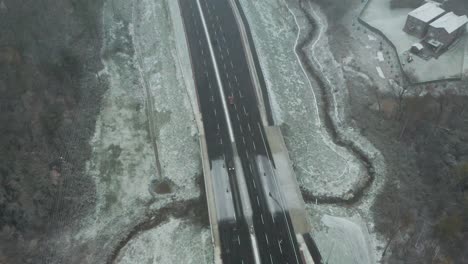 un avión volando sobre una autopista durante una tormenta de nieve en el campo canadiense