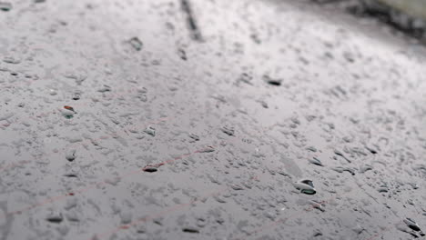 dew drops on wet rear windshield of a car on a dramatic morning