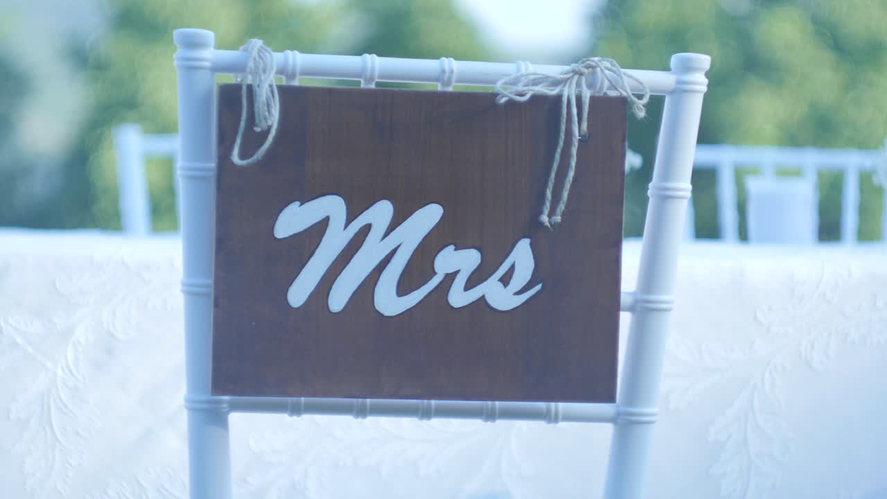 Sedute nuziali a un tavolo da pranzo all'aperto in un allestimento per matrimonio esterno
