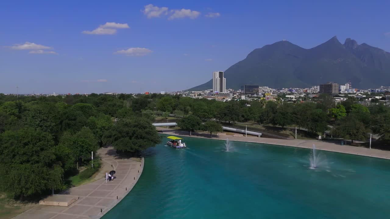 An artificial river in the middle of the city where they offer tours to show the entire river, with a hill called Cerro de la Silla in the background (4K 60fps)