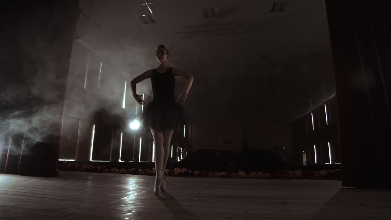 Prima ballerina on pointes training on stage with spotlights in late evening before important performance in Opera and Ballet theatre.