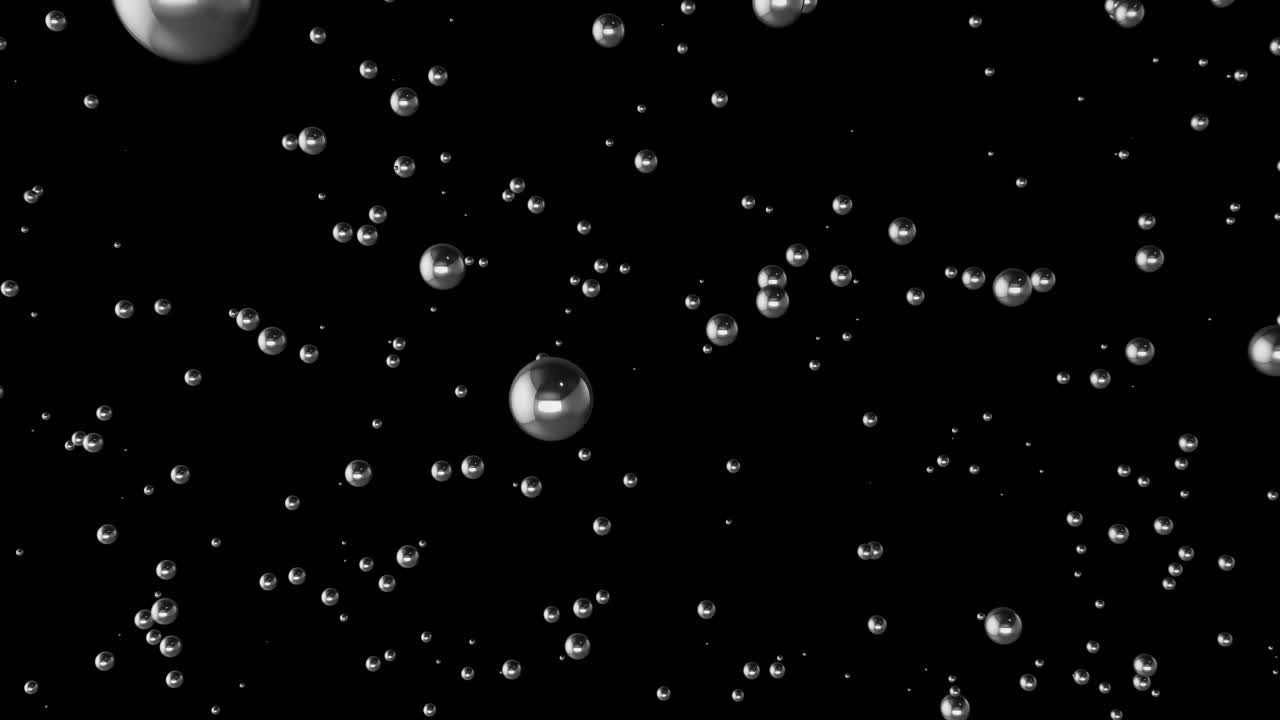 Small Chrome Balls Moving Past Camera to Reveal Dozens of Particles Heading Towards Black Background