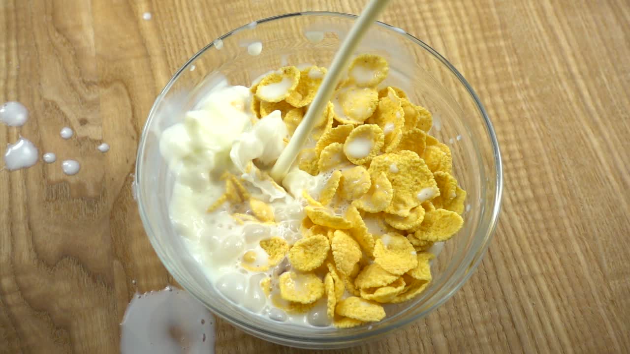 I corn flakes vengono versati con il latte. Rallentatore.