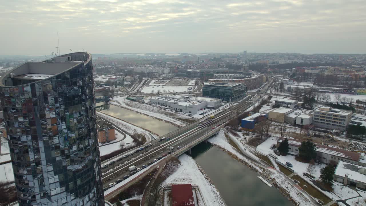 Aerial view of the city of Olomouc from behind a tall building and winter landscape covered with snow