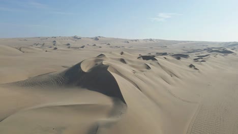 drone gracefully advances, capturing the beauty of the desert dunes near huacachina