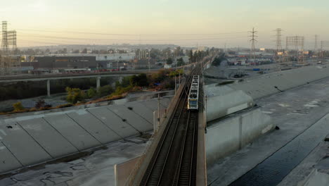 los angeles metro train crossing la river at sunrise/sunset